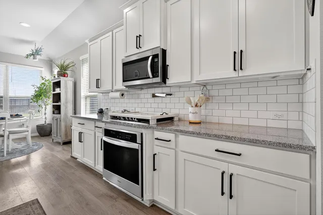 a kitchen with white cabinets stainless steel appliances and sink