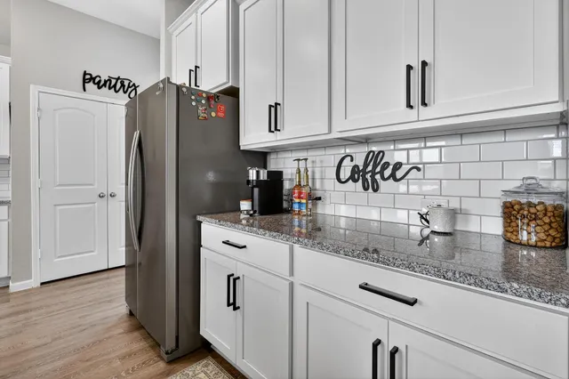 a kitchen with stainless steel appliances granite countertop a refrigerator and cabinets