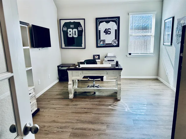 a view of a workspace with furniture and wooden floor
