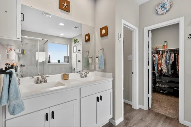 a en suite bathroom with a sink double vanity and shower