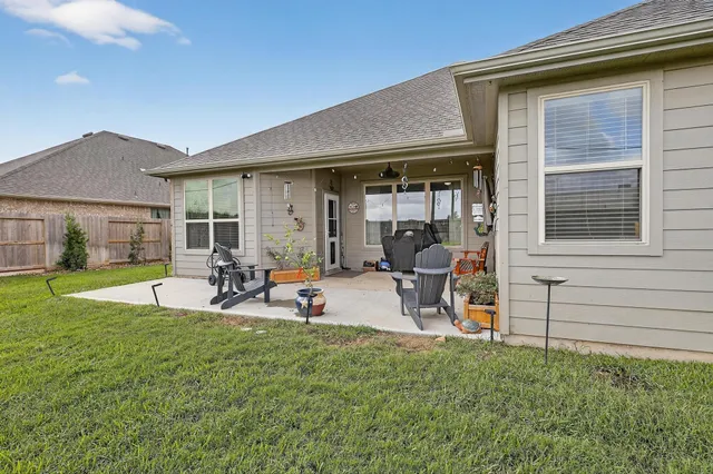 a view of a backyard with table and chairs under an umbrella