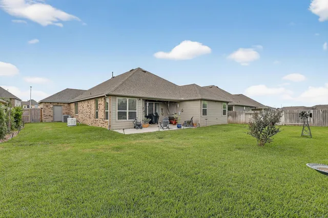 a view of a house with a big yard and a large tree