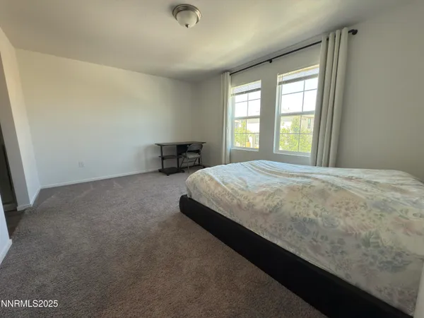 a large bed sitting in a room next to a window