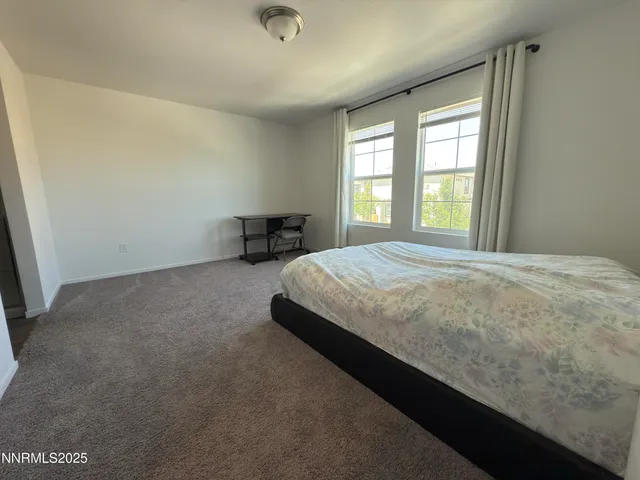 a large bed sitting in a room next to a window