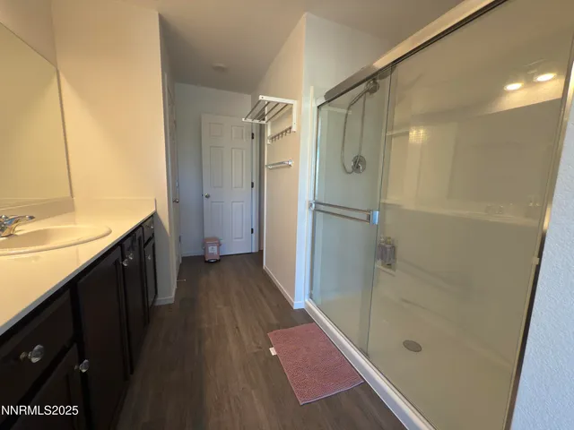 a bathroom with a double vanity sink a toilet and shower