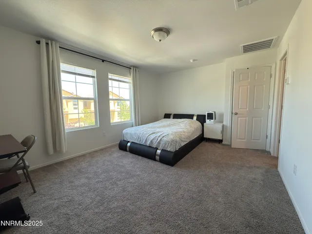 a spacious bedroom with a bed and a window