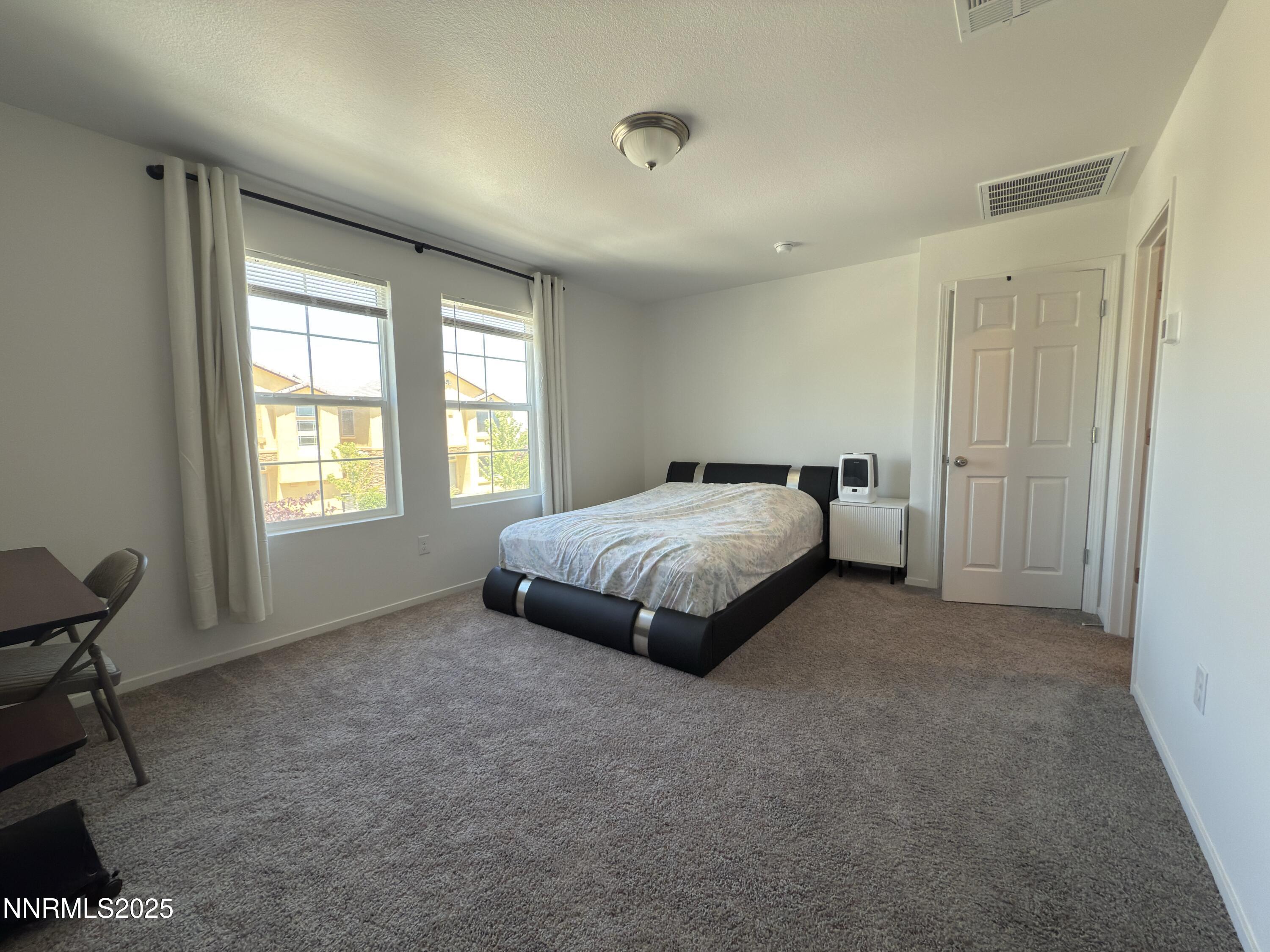 9774 Silver Dollar Lane Reno, NV 89506 - Photo 22 of 26 a spacious bedroom with a bed and a window