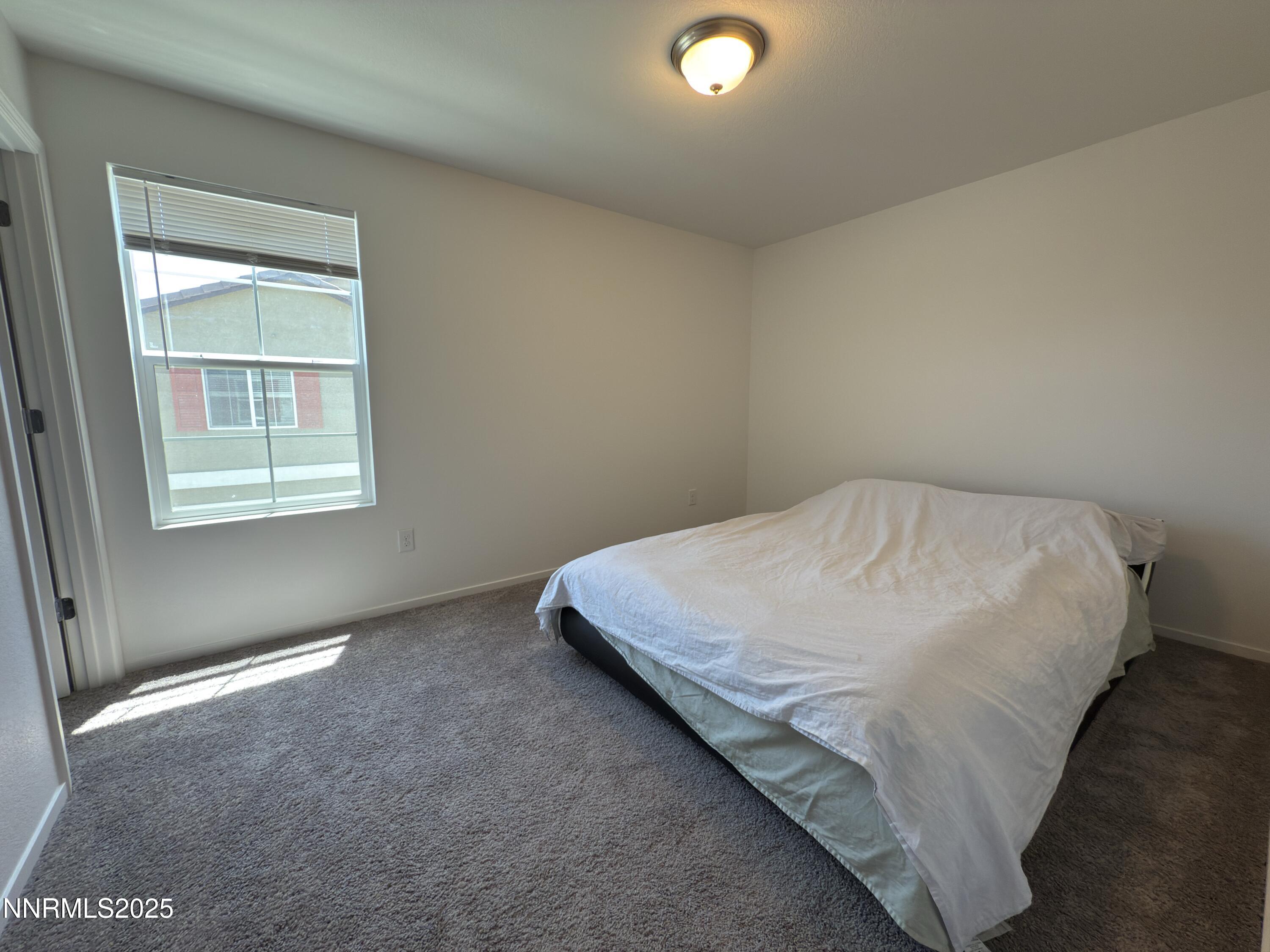 9774 Silver Dollar Lane Reno, NV 89506 - Photo 23 of 26 a bed sitting in a bedroom next to a window