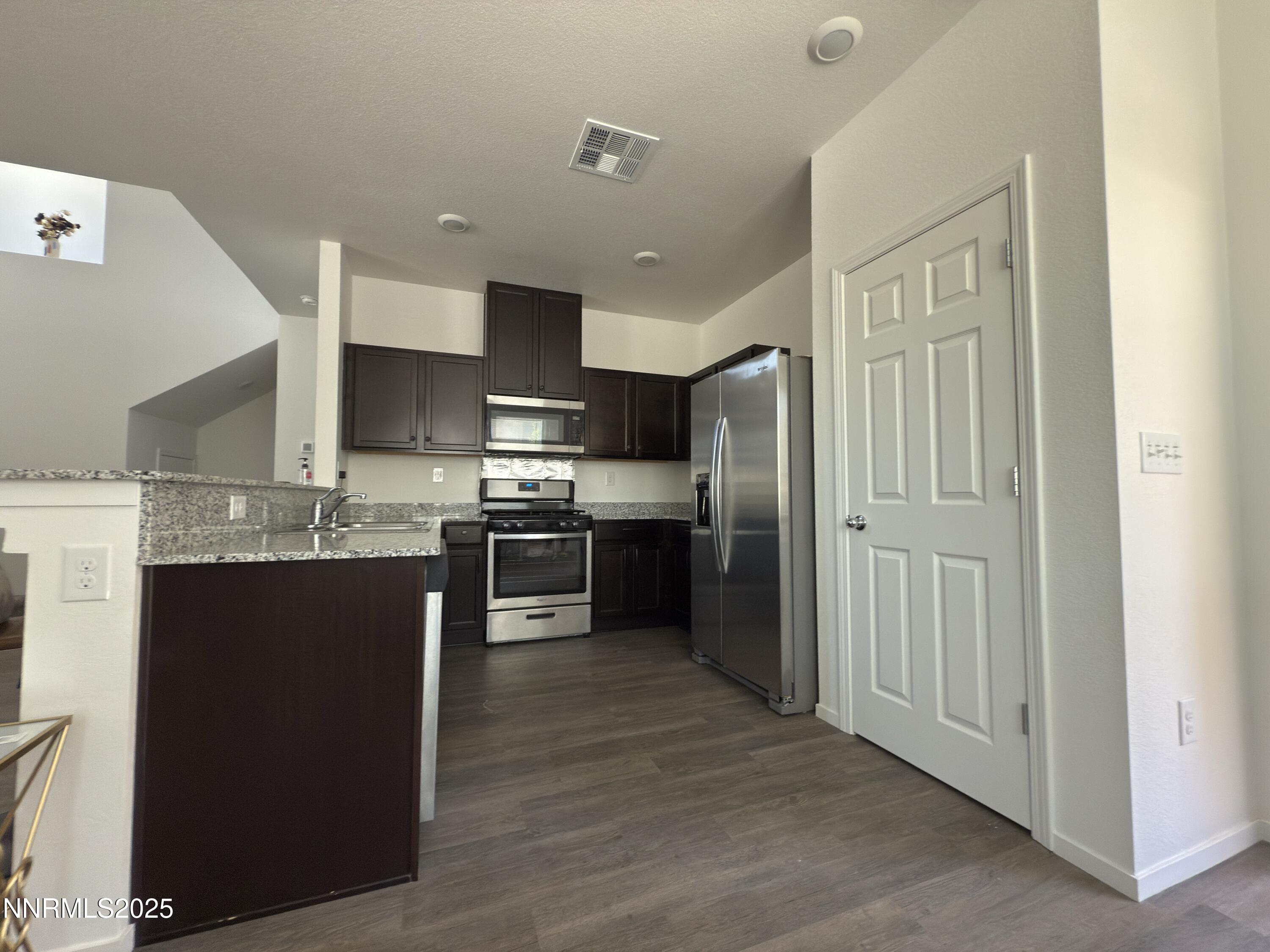 9774 Silver Dollar Lane Reno, NV 89506 - Photo 6 of 26 a kitchen with stainless steel appliances granite countertop a refrigerator a sink a stove and oven