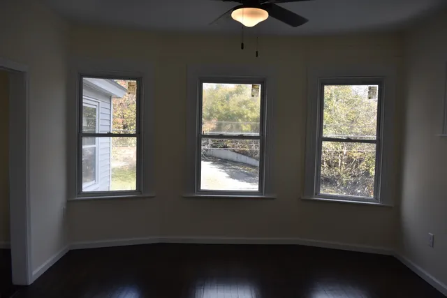 a view of room with two window and wooden floor