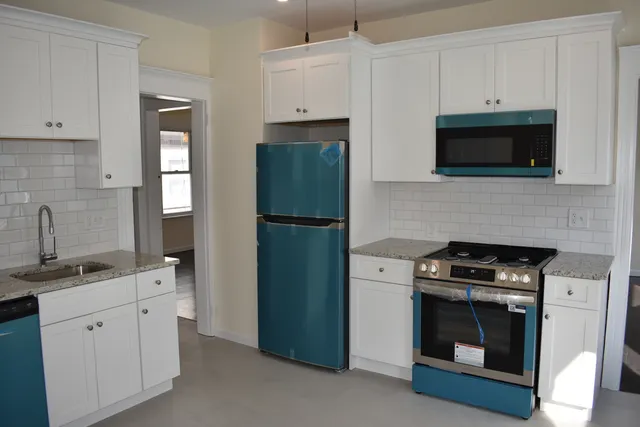a kitchen with cabinets stainless steel appliances and a counter space