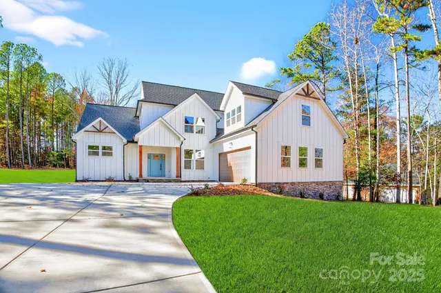 a front view of a house with a garden and trees