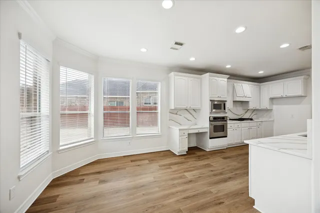 a view of kitchen with refrigerator cabinets and wooden floor