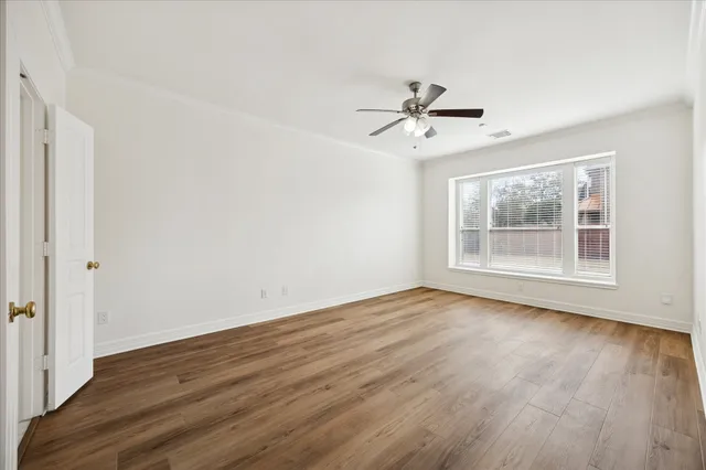 a view of room with hardwood floor ceiling fan and window