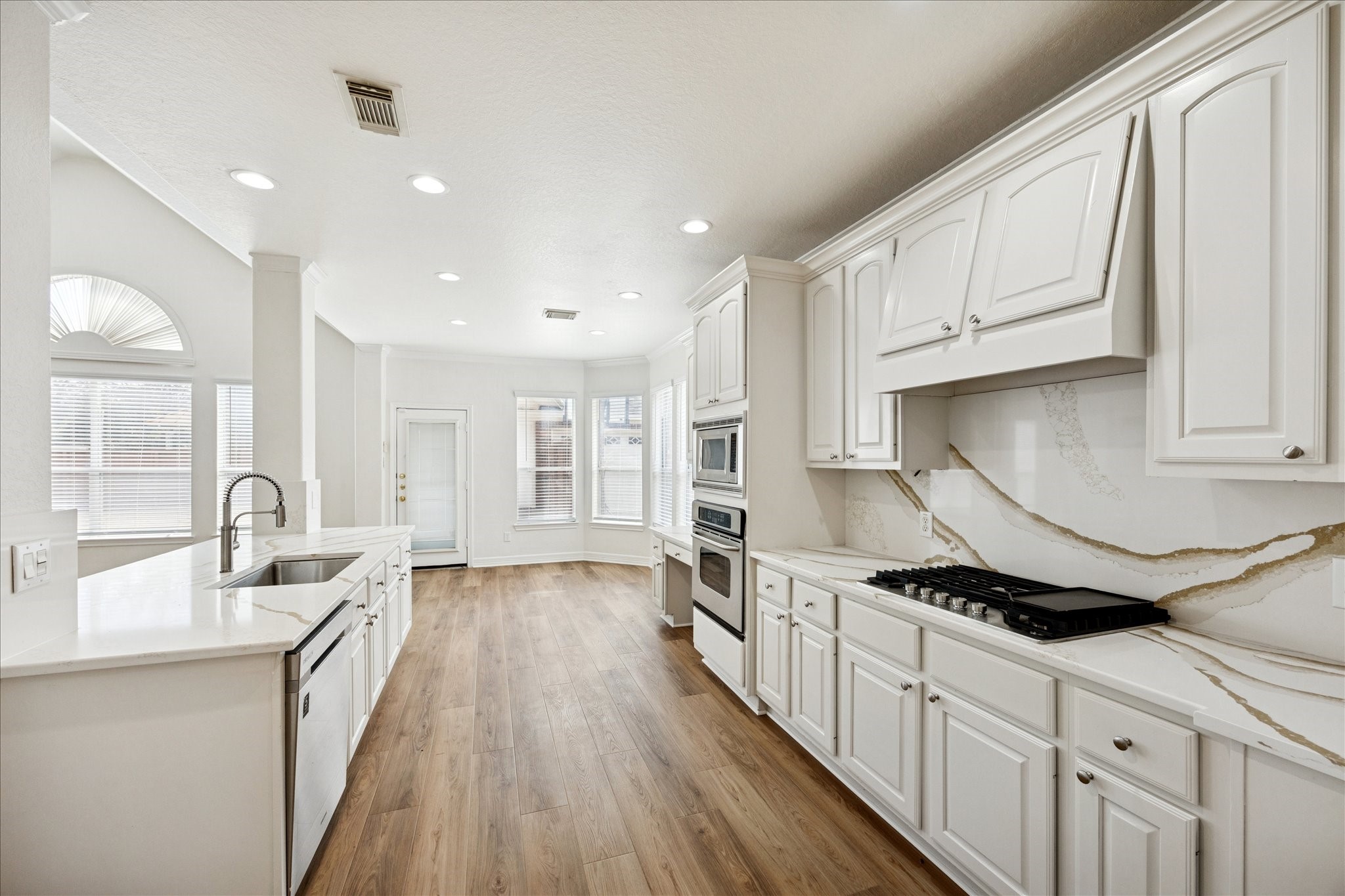 12003 Ensenada Canyon Lane Houston, TX 77041 - Photo 8 of 28 Well designed kitchen with white cabinetry and a breakfast room that opens to the living space.