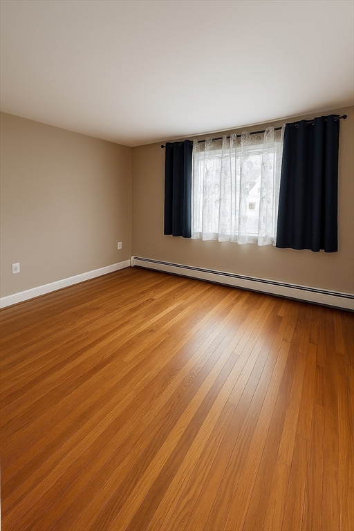 45 Roswell Avenue, Unit 2 Dracut, MA 01826 - Photo 2 of 5 a view of an empty room with wooden floor and a window