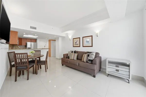 a living room with furniture a dining table and a flat screen tv