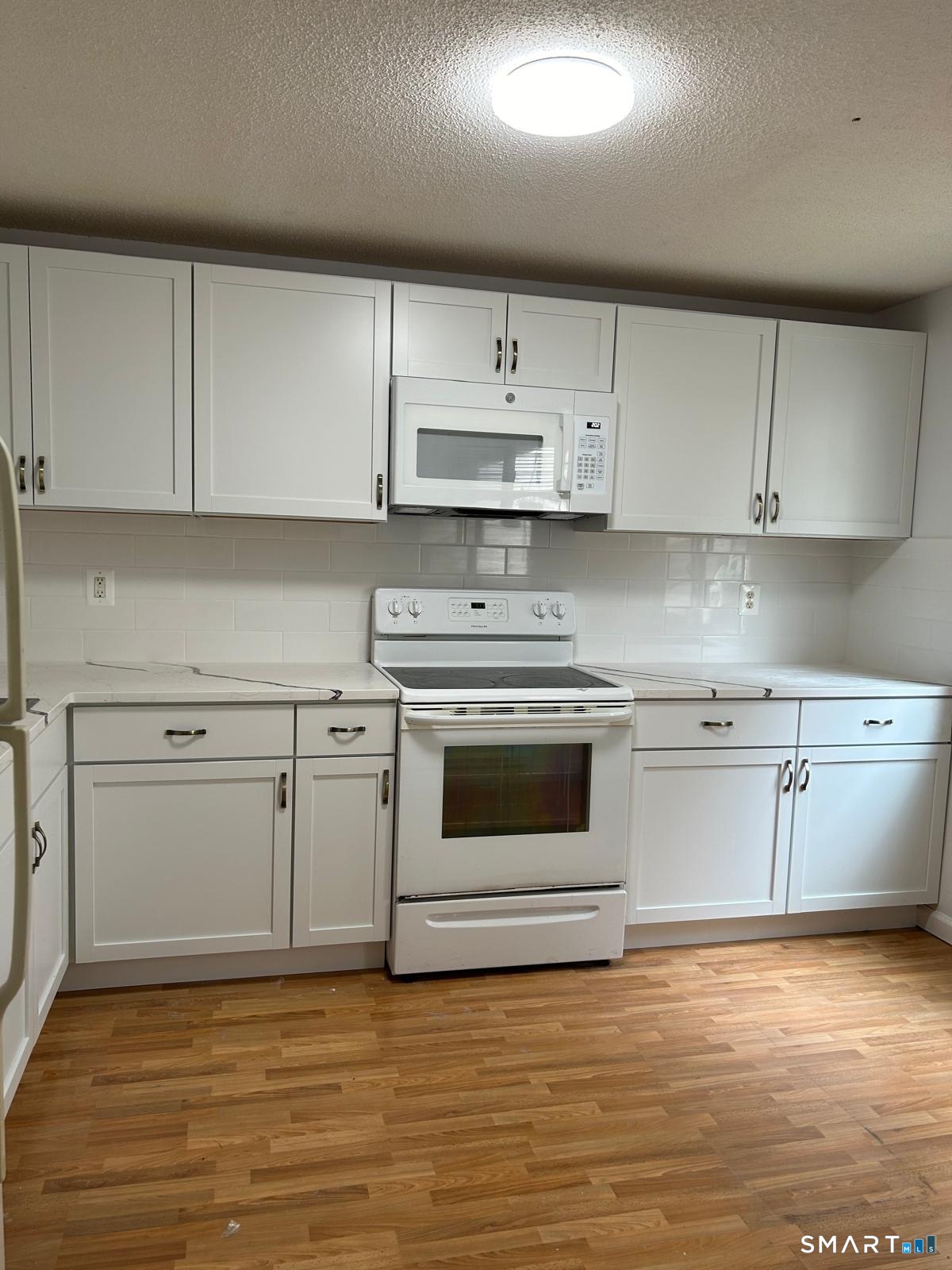 a kitchen with cabinets stainless steel appliances and a counter space