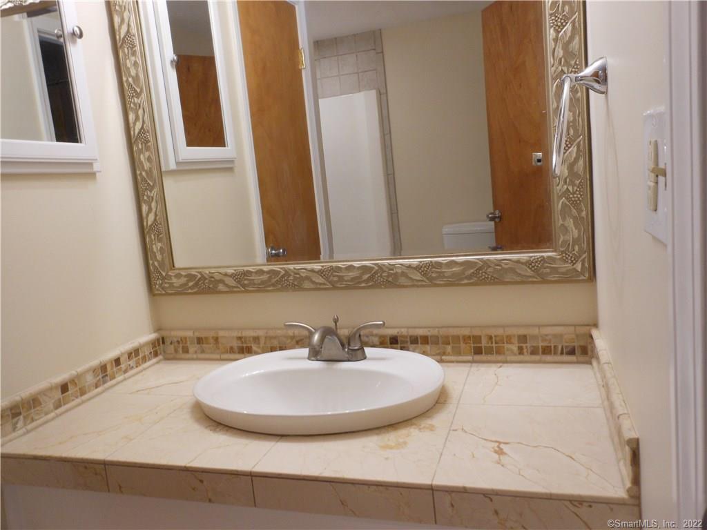 7 Padanaram Road, Unit C58 Danbury, CT 06811 - Photo 11 of 17 a bathroom with a sink and a mirror