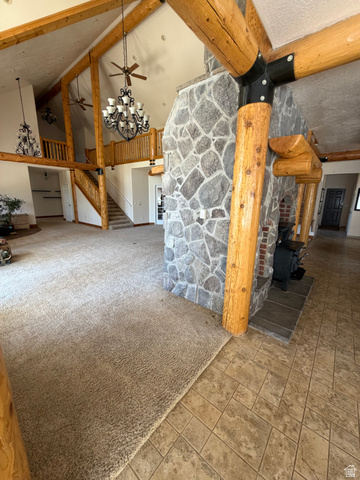 4458 East Glencoe Road Preston, ID 83263 - Photo 8 of 46 Vaulted ceilings with exposed wood beams, a stone-clad fireplace with a wood-burning stove, and a grand staircase with wood railings
