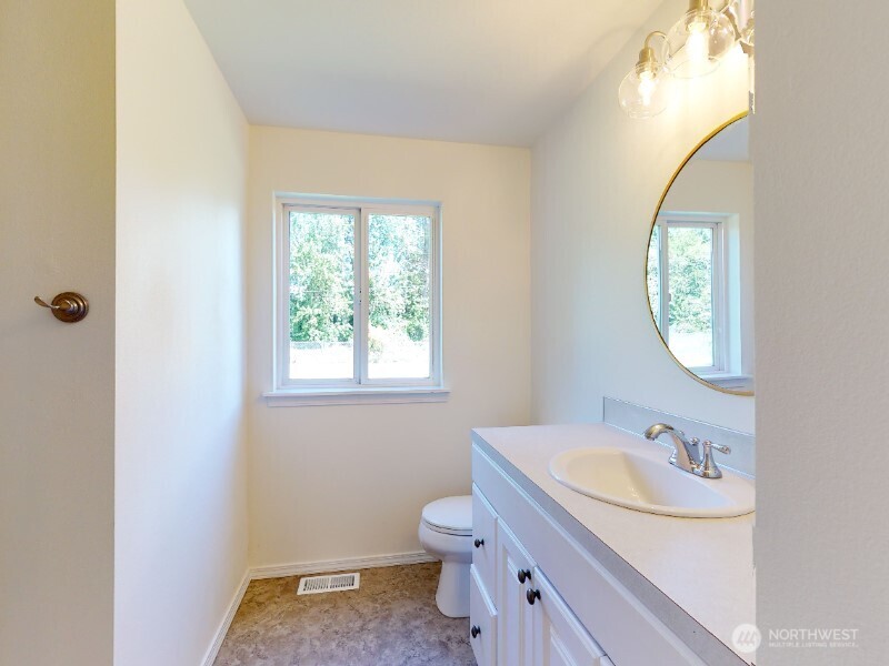 551 South Sullivan Street Seattle, WA 98108 - Photo 11 of 24 a bathroom with a toilet a sink a mirror and a window
