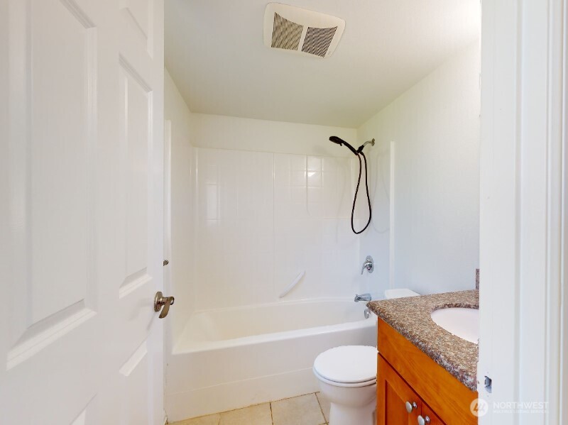 551 South Sullivan Street Seattle, WA 98108 - Photo 21 of 24 a bathroom with a granite countertop bathtub shower sink and toilet