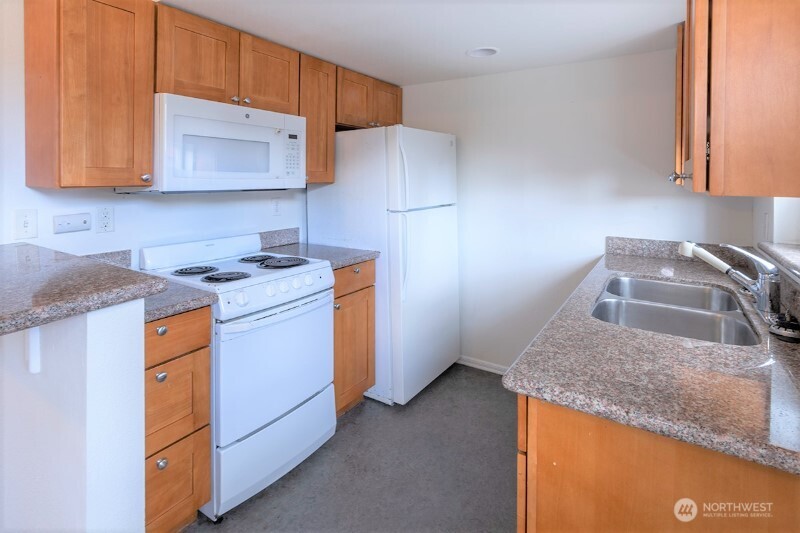 551 South Sullivan Street Seattle, WA 98108 - Photo 22 of 24 a kitchen with stainless steel appliances granite countertop a sink stove and refrigerator