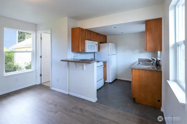 a view of kitchen with wooden floor and electronic appliances