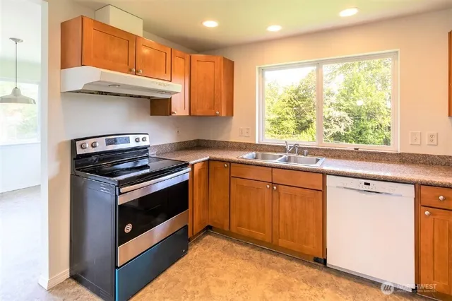 a kitchen with stainless steel appliances granite countertop a sink a stove and a microwave