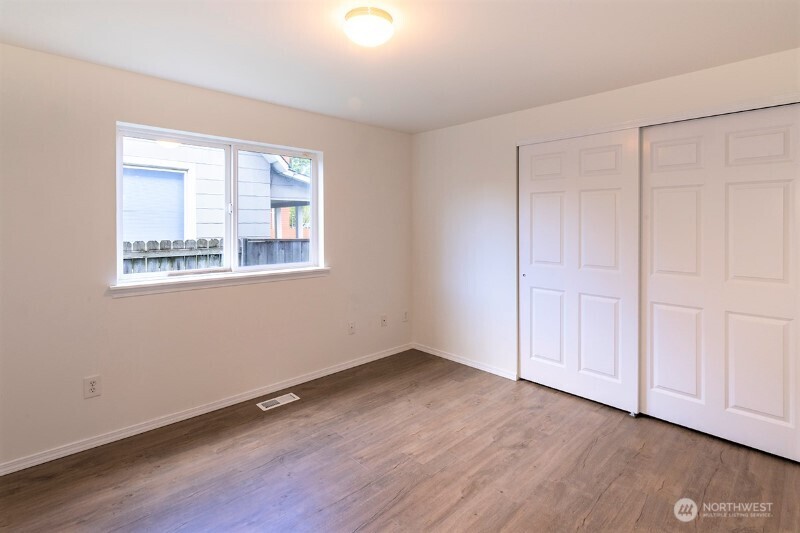 551 South Sullivan Street Seattle, WA 98108 - Photo 10 of 24 a view of an empty room with wooden floor and a window