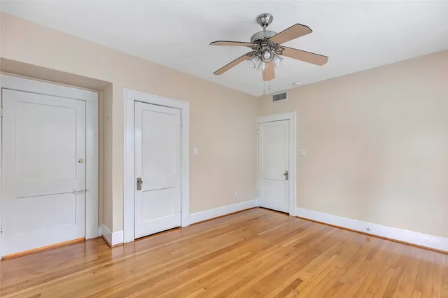 a view of room with wooden floor and ceiling fan