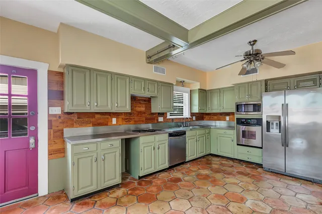 a kitchen with stainless steel appliances granite countertop a stove a sink and a refrigerator