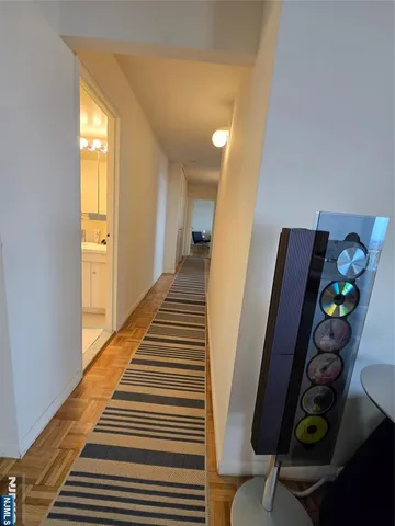 a hallway with painting on the wall and a window