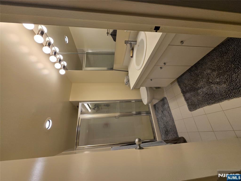 1275 15th Street, Unit PHB Fort Lee, NJ 07024 - Photo 13 of 14 a bathroom with a double vanity sink mirror and shower