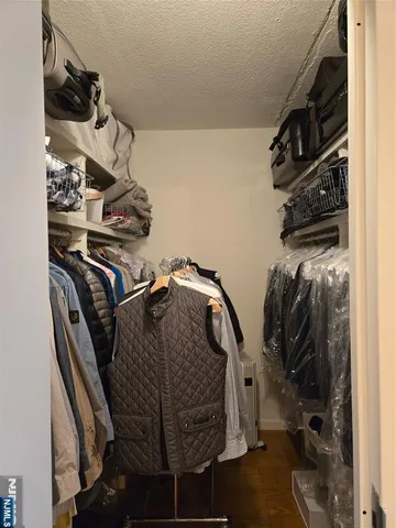 a view of walk in closet with clothes and shoes