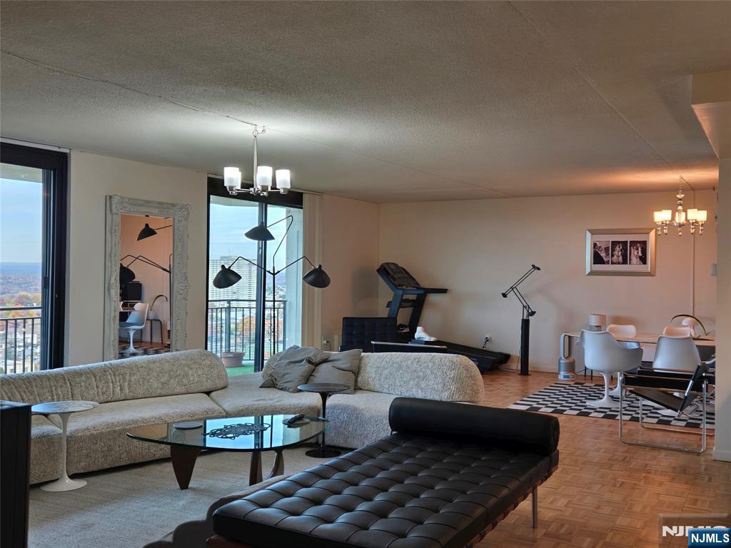 1275 15th Street, Unit PHB Fort Lee, NJ 07024 - Photo 3 of 14 a living room with furniture a lamp and a chandelier