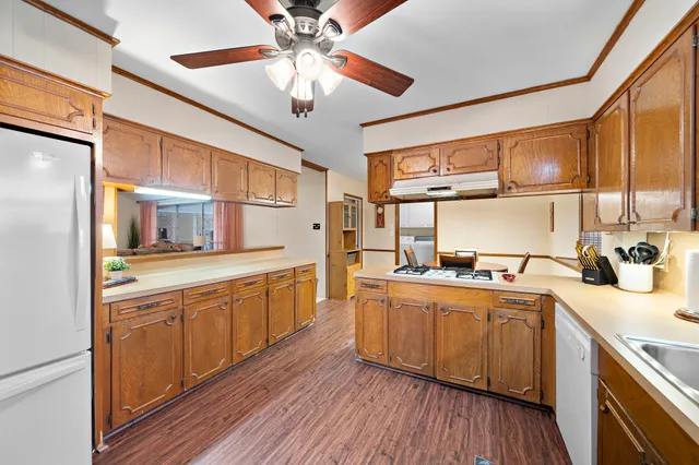 a kitchen with stainless steel appliances a sink cabinets and wooden floor