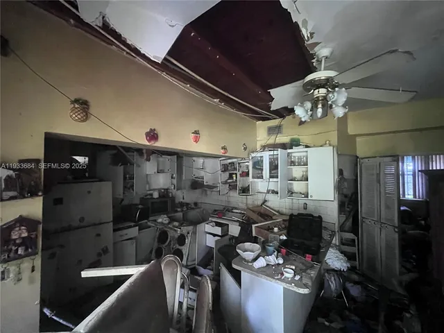 a room with a microwave a stove and furniture