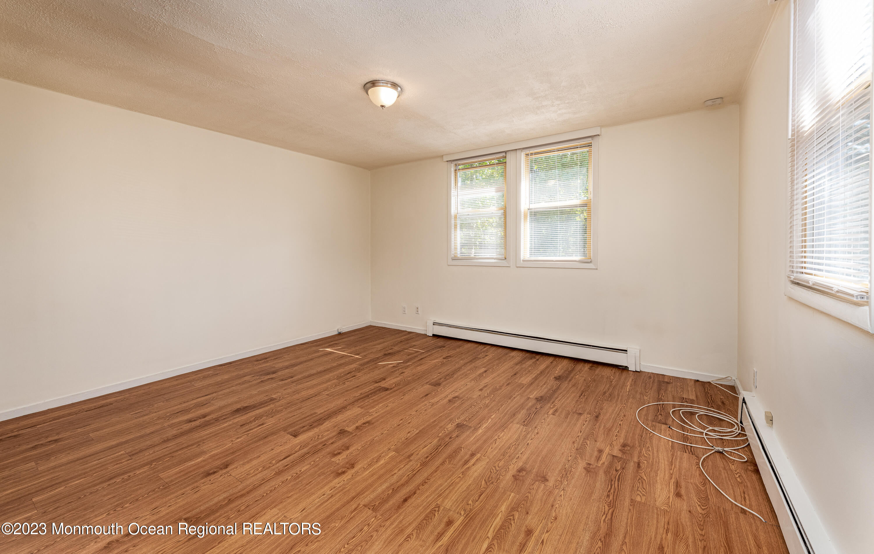 508 Georgia Tavern Road Howell, NJ 07731 - Photo 22 of 33 an empty room with wooden floor and windows