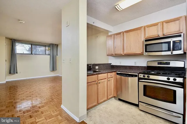 a kitchen with stainless steel appliances white cabinets and a stove top oven