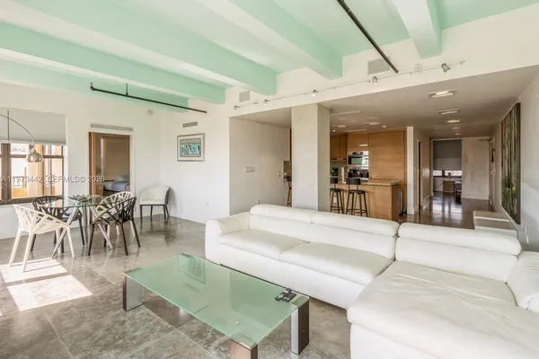 a dining hall with stainless steel appliances granite countertop a table and chairs