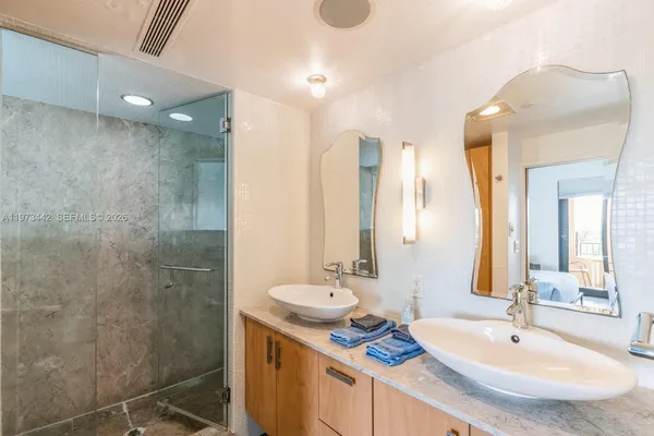 a bathroom with a sink vanity granite tub shower and a mirror