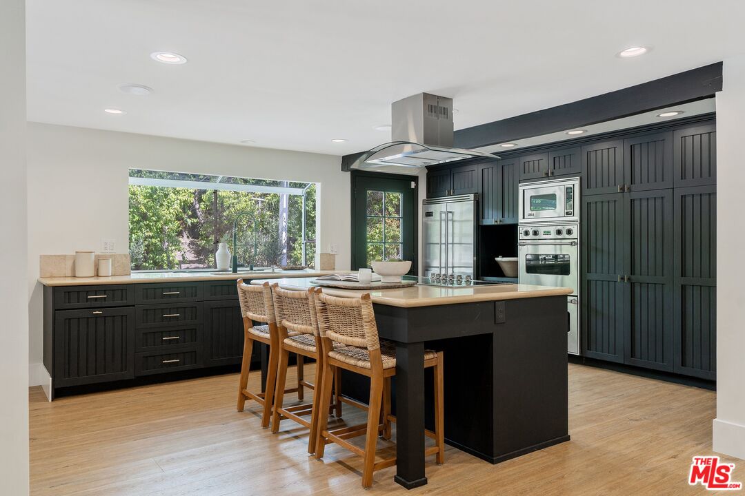 22801 Pera Road Woodland Hills, CA 91364 - Photo 15 of 46 a kitchen with a table chairs sink and wooden floor
