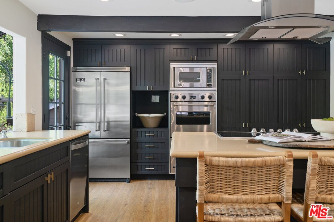 22801 Pera Road Woodland Hills, CA 91364 - Photo 17 of 46 a kitchen with stainless steel appliances kitchen island granite countertop a refrigerator and a stove top oven