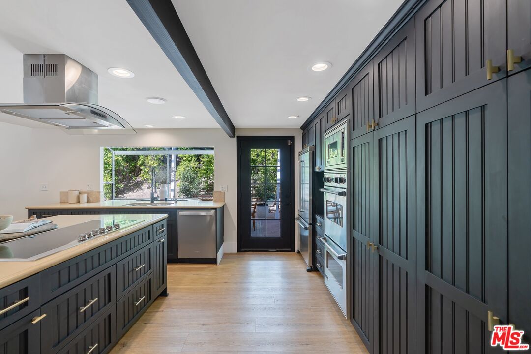 22801 Pera Road Woodland Hills, CA 91364 - Photo 18 of 46 a kitchen with a sink stove and cabinets