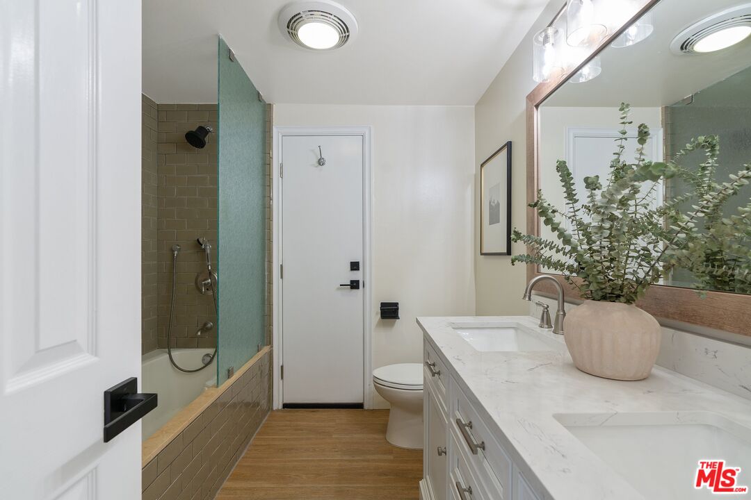 22801 Pera Road Woodland Hills, CA 91364 - Photo 24 of 46 a bathroom with a granite countertop sink a toilet and shower