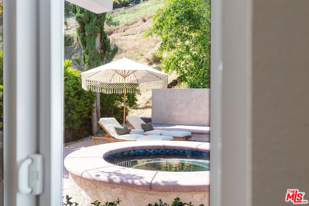 22801 Pera Road Woodland Hills, CA 91364 - Photo 34 of 46 a kitchen view with a fireplace and chandelier
