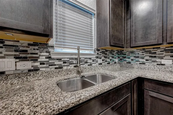 a kitchen with granite countertop a sink and a stove
