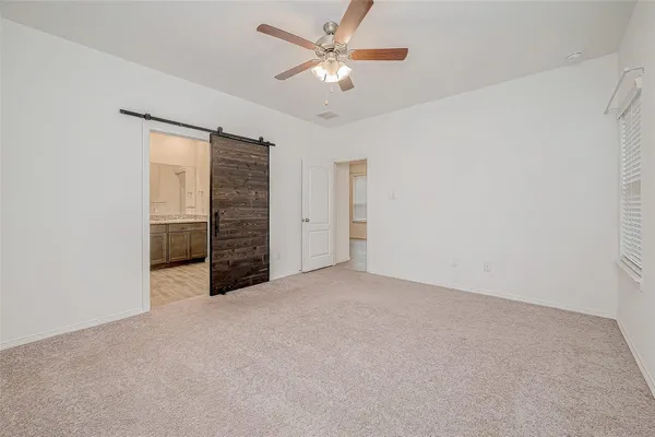 an empty room with closet and a ceiling fan