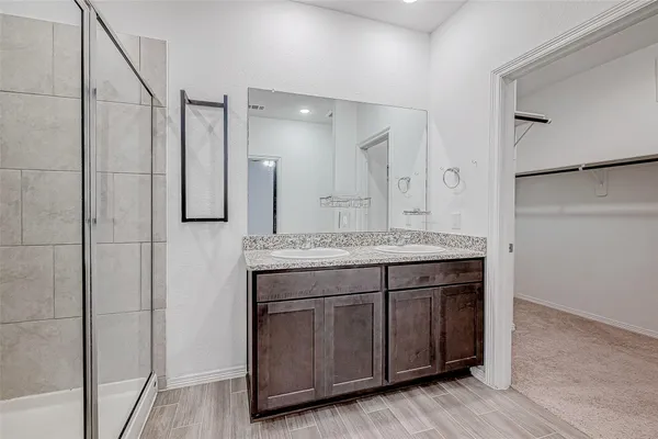 a bathroom with a granite countertop sink a mirror and a shower